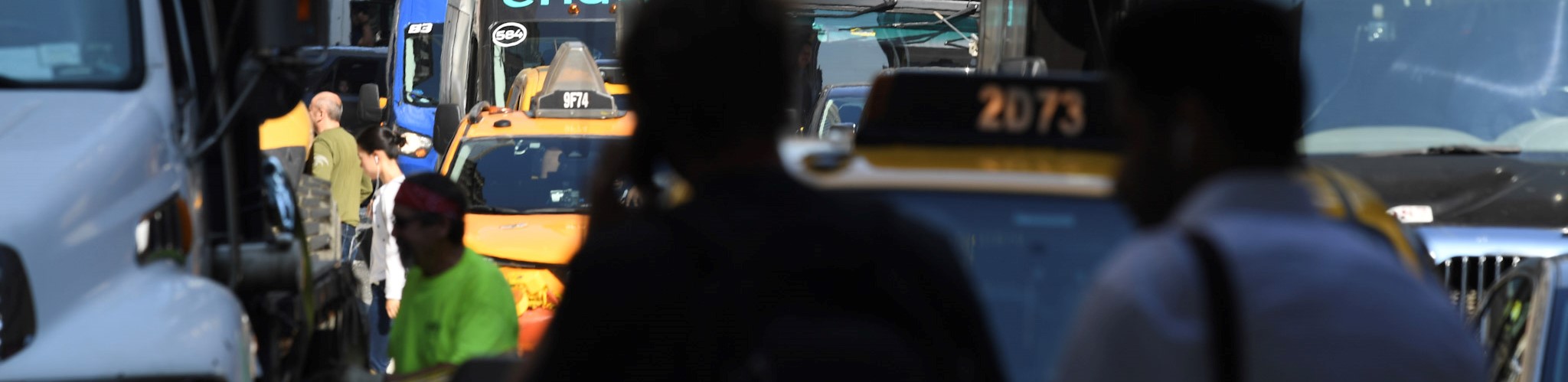 Pedestrians walk around vehicles stuck in traffic in Midtown Manhattan